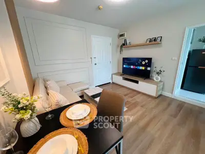 Modern living room with stylish decor and open layout, featuring a cozy sofa and entertainment center.