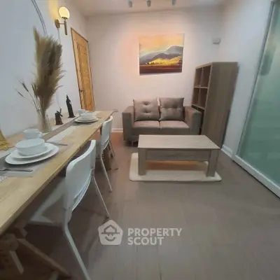 Cozy living room with modern decor and dining area, perfect for small gatherings.