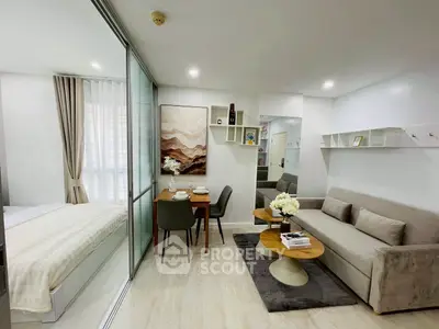 Modern open-plan living room with dining area and cozy bedroom in stylish apartment.