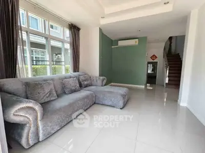 Spacious living room with plush gray sofa and large windows in modern home