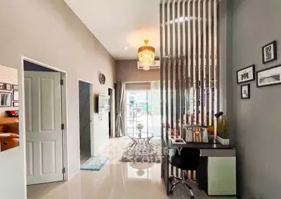 Modern living room with elegant decor and open layout, featuring a stylish chandelier and sleek furniture.