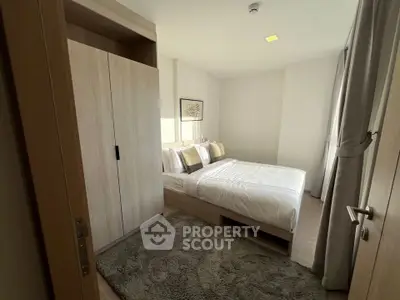 Cozy bedroom with modern decor and ample natural light, featuring a plush bed and stylish wardrobe.
