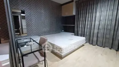 Modern bedroom with stylish wallpaper and glass desk, featuring a comfortable bed and elegant curtains.