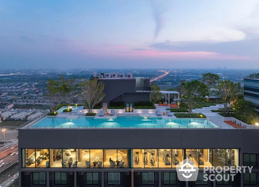 Stunning rooftop pool with panoramic city views at sunset, modern luxury living.