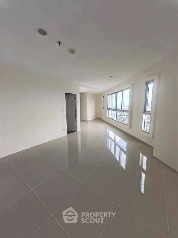 Spacious empty living room with large windows and city view, perfect for customization.