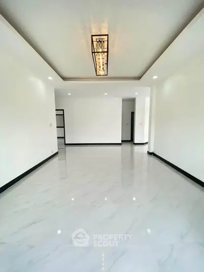 Spacious modern living room with elegant lighting and glossy tile flooring
