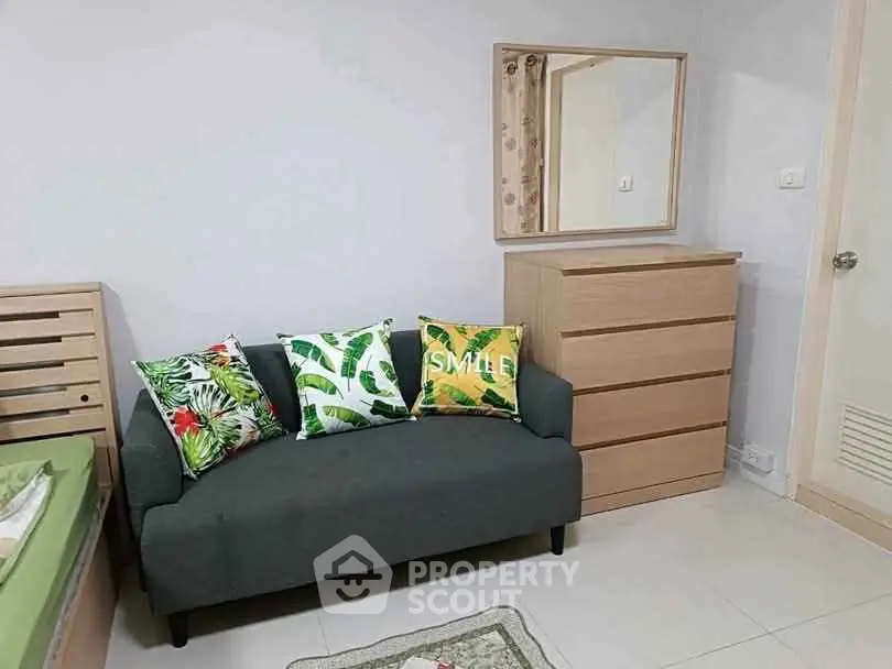 Cozy living room with modern sofa and vibrant cushions, perfect for relaxation.