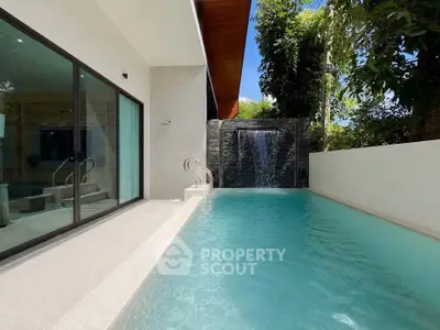 Luxurious private pool with waterfall feature in modern villa setting