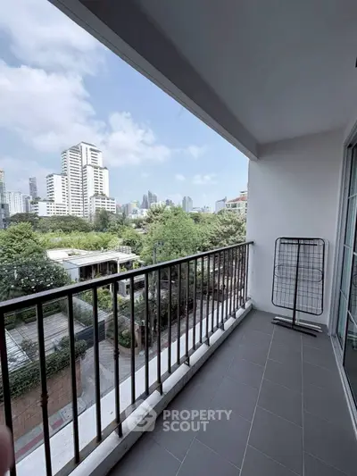 Spacious balcony with city skyline view, perfect for relaxation and enjoying urban living.