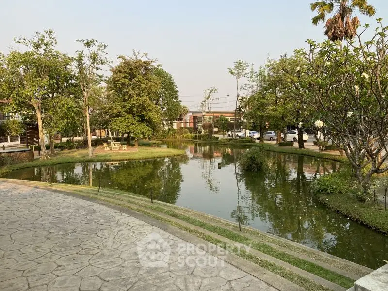 Serene garden view with pond and lush greenery in a tranquil setting.