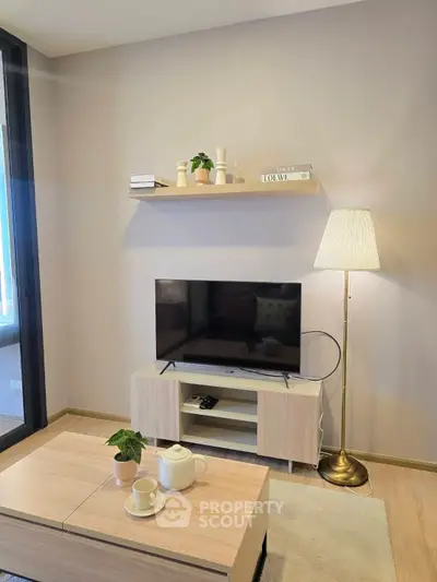 Modern living room with sleek TV stand, cozy lighting, and stylish decor for a welcoming ambiance.