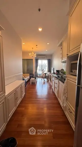 Charming open-layout kitchen and living area with elegant wooden flooring and natural light.