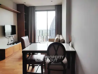 Modern living room with balcony view, stylish furniture, and natural light.