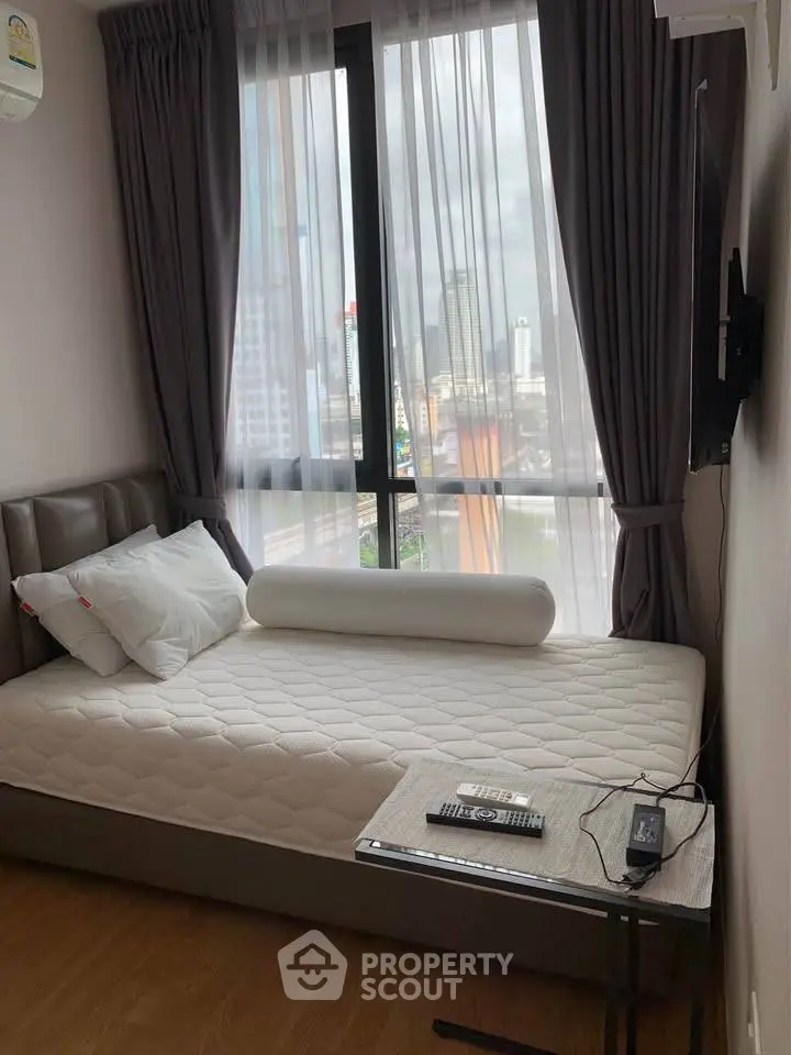 Cozy bedroom with city view, featuring a comfortable bed and modern decor.