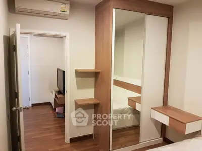 Modern bedroom with mirrored wardrobe and wooden flooring