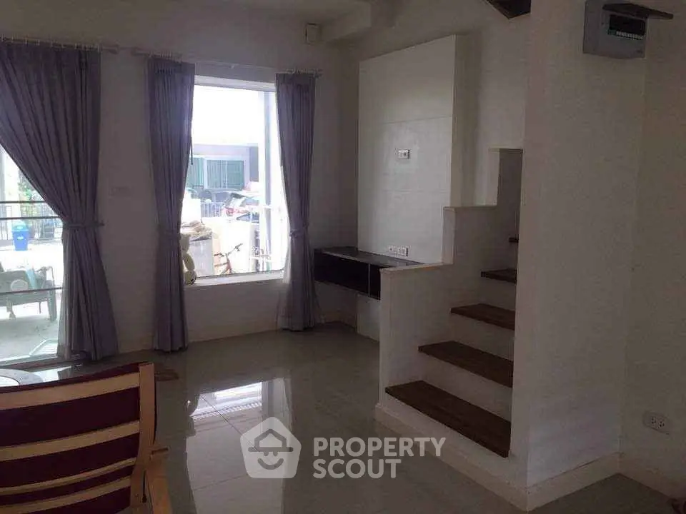 Modern interior with staircase and large window, perfect for natural light lovers.