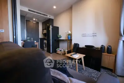 Modern living room with stylish decor and compact kitchen area, featuring a washing machine and sleek appliances.