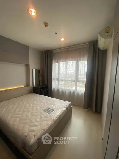 Modern bedroom with large window and stylish decor, offering a cozy and inviting atmosphere.