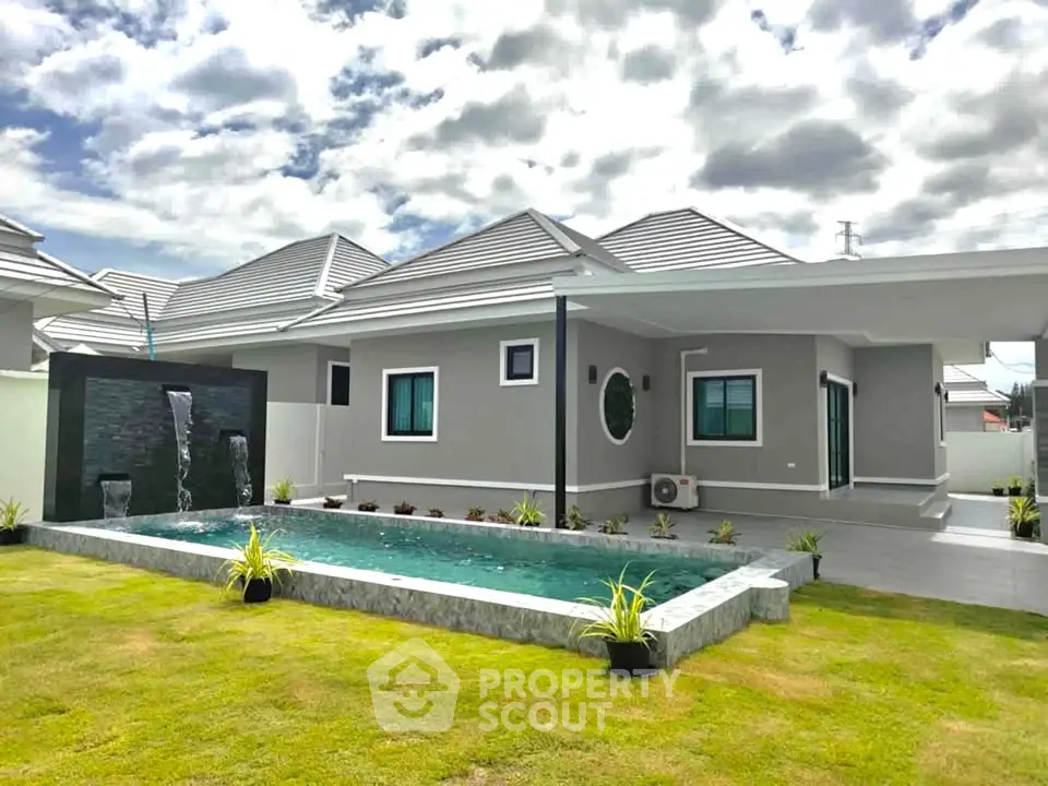Modern single-story house with private pool and landscaped garden under a cloudy sky.