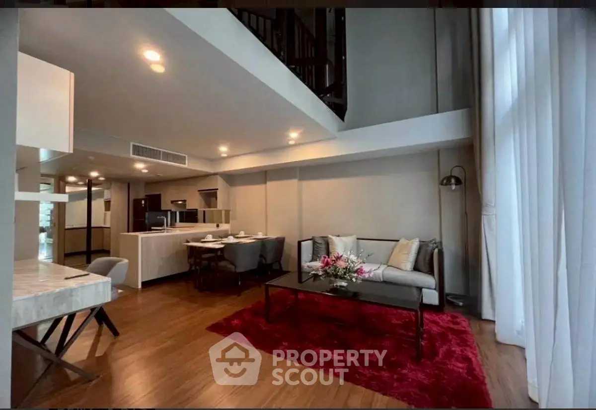 Spacious modern living room with high ceilings and elegant decor in a luxury apartment.