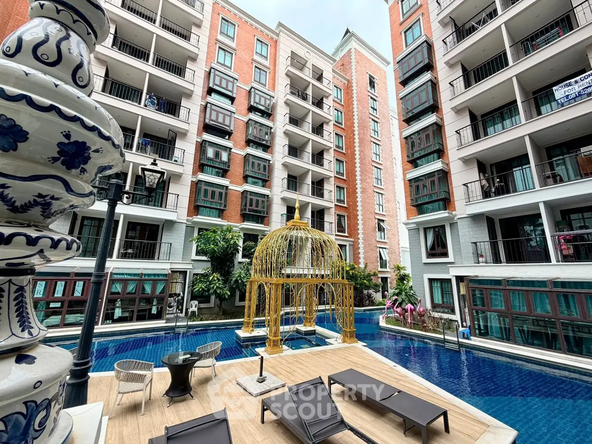 Luxurious apartment complex with poolside relaxation area and elegant architecture.
