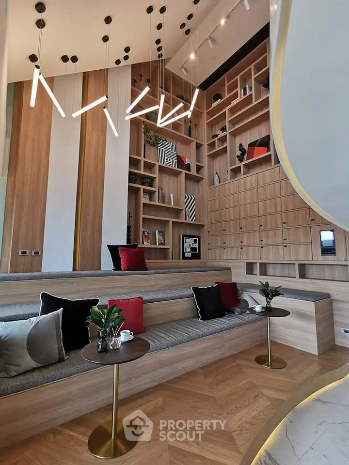 Modern living room with high ceilings, stylish lighting, and built-in wooden shelving.