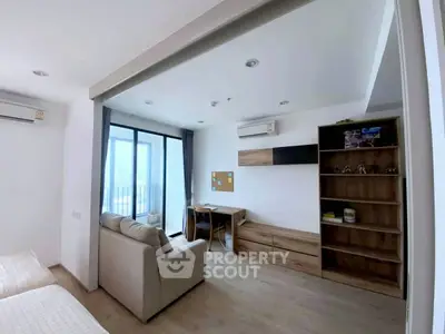 Modern living room with study area and large windows offering natural light.