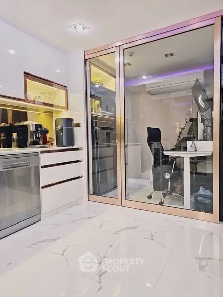 Modern kitchen with sleek appliances and adjacent glass-enclosed study area.
