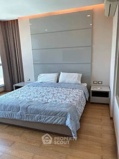 Spacious modern bedroom with stylish decor and large windows for natural light.