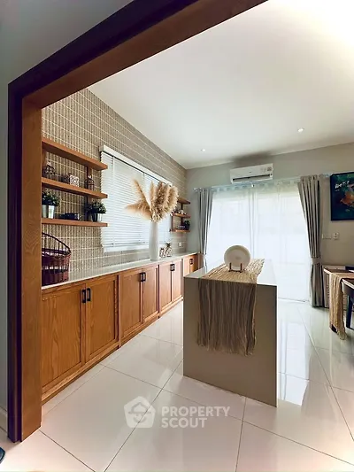 Spacious modern living room with natural light and stylish wooden cabinetry.