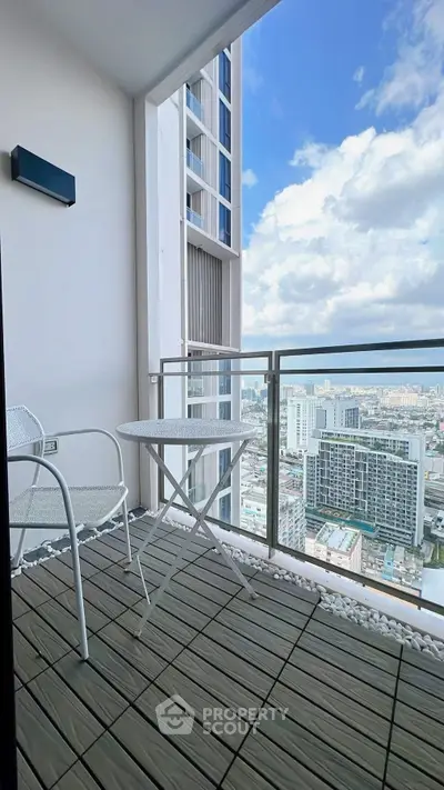 Modern balcony with stunning city view and stylish outdoor furniture.