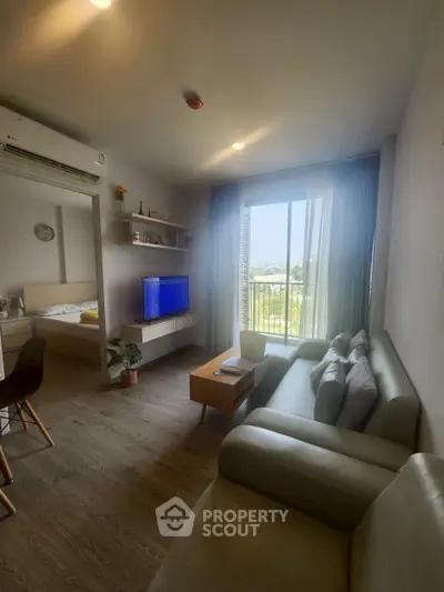 Modern living room with cozy sofa and large window offering a scenic view