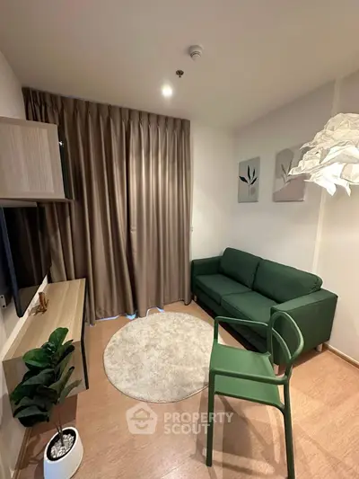 Cozy modern living room with green sofa, stylish decor, and wooden flooring.