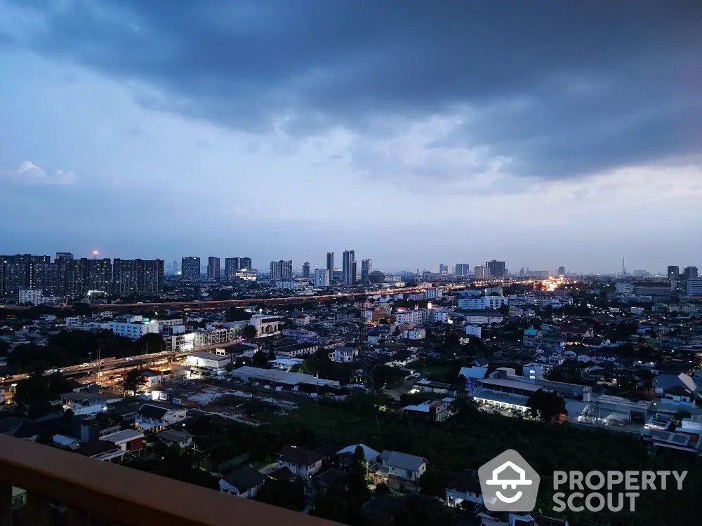 Stunning cityscape view from high-rise balcony at dusk, showcasing urban skyline and vibrant lights.