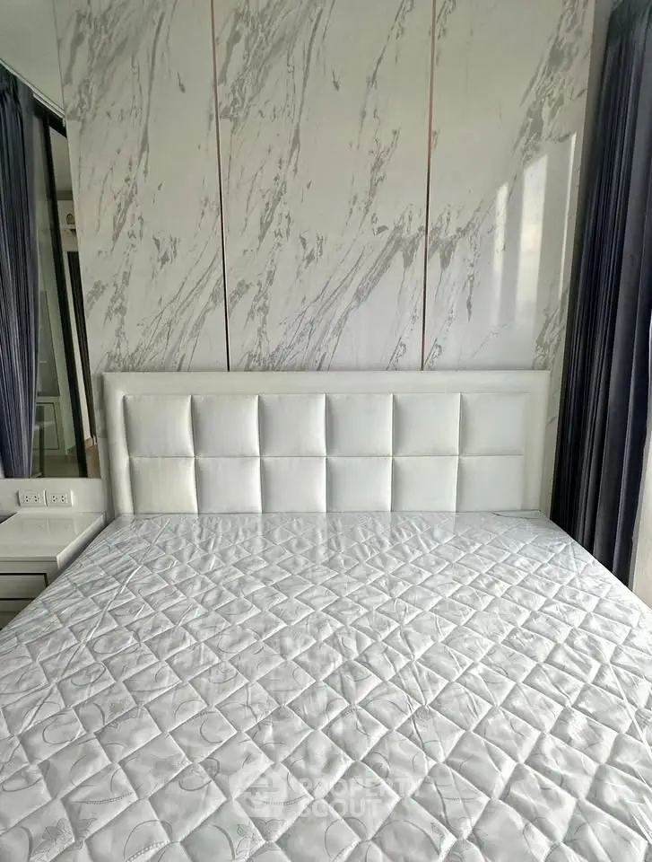 Luxurious bedroom with elegant marble accent wall and plush white headboard