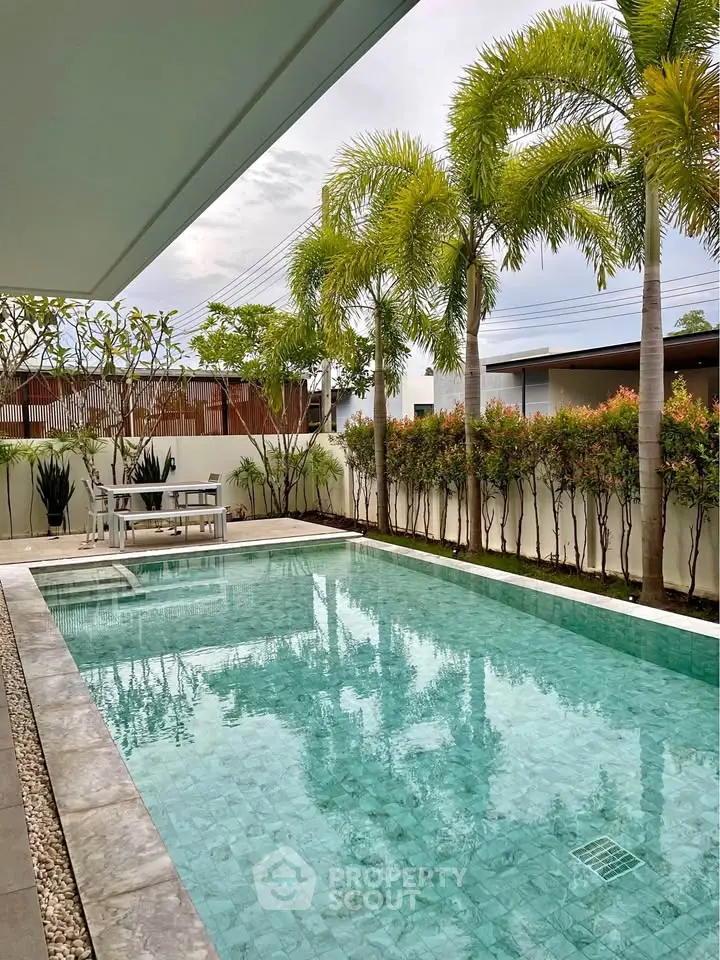 Luxurious private pool with tropical landscaping in modern villa setting.