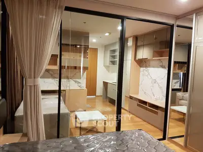 Modern bedroom with glass partition and stylish decor in a contemporary apartment.