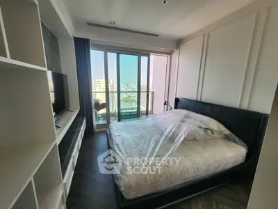 Modern bedroom with large window and city view, featuring a sleek bed and built-in shelving.
