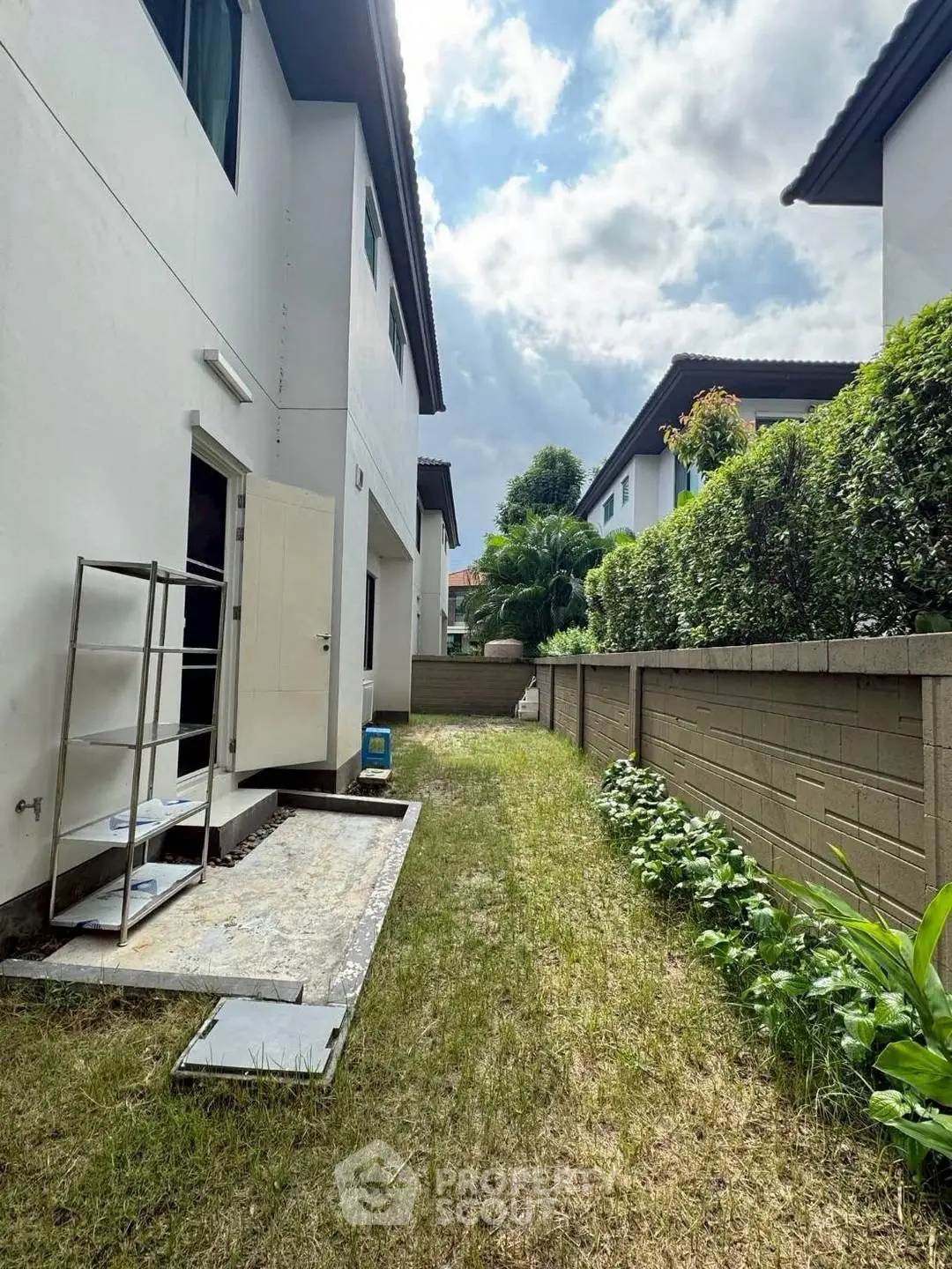 Charming backyard with lush greenery and modern exterior, perfect for outdoor relaxation.