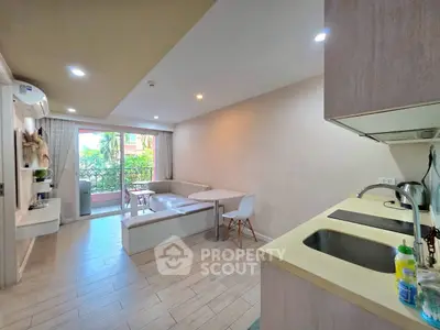 Modern open-plan living room with kitchen and balcony view