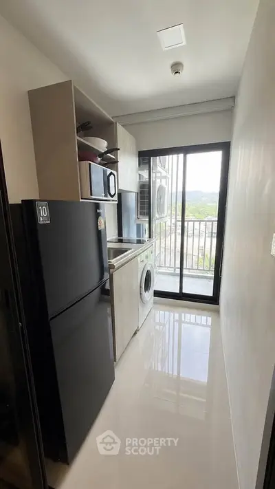 Modern kitchen with sleek appliances and balcony view