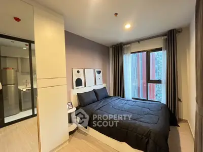 Modern bedroom with stylish decor and large window offering city view