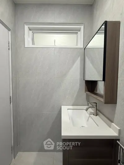 Modern bathroom with sleek vanity and wall-mounted mirror in minimalist design.
