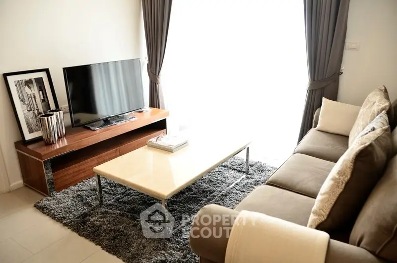 Stylish living room with modern decor, plush sofa, and sleek TV setup.