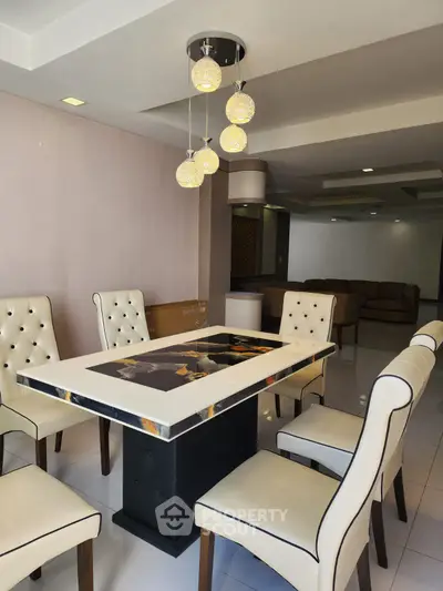 Elegant dining area with modern chandelier and stylish seating in a spacious living space.