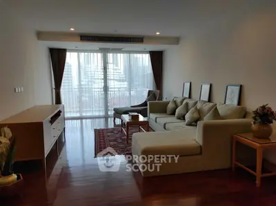 Spacious living room with modern sofa and city view balcony, perfect for urban living.
