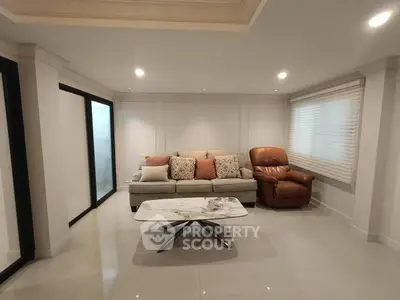 Spacious living room with modern sofa and recliner, elegant decor, and sleek marble coffee table.