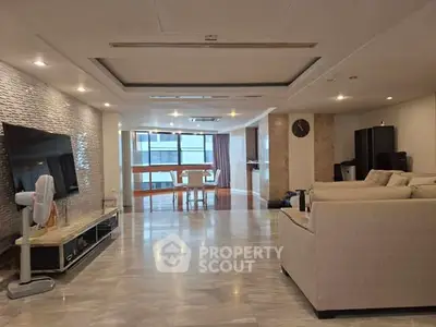 Spacious modern living room with elegant decor and large windows for natural light.