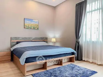 Modern bedroom with stylish decor and natural light, featuring a cozy bed and elegant curtains.