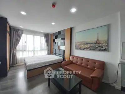 Modern bedroom with stylish decor and large window offering natural light